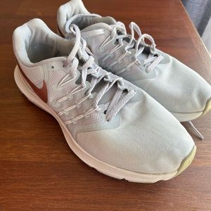 Nike running shoes with rose gold logo
